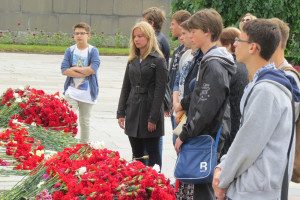 Young Russians place flowers and ponder humanity’s unflattering past. 